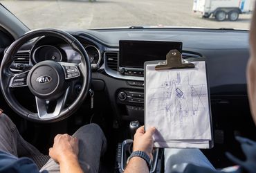 Fahrschüler mit Übungsplan im Kia