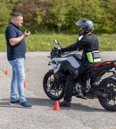 Fahrlehrer mit Motorradschülerin auf dem Übungsplatz